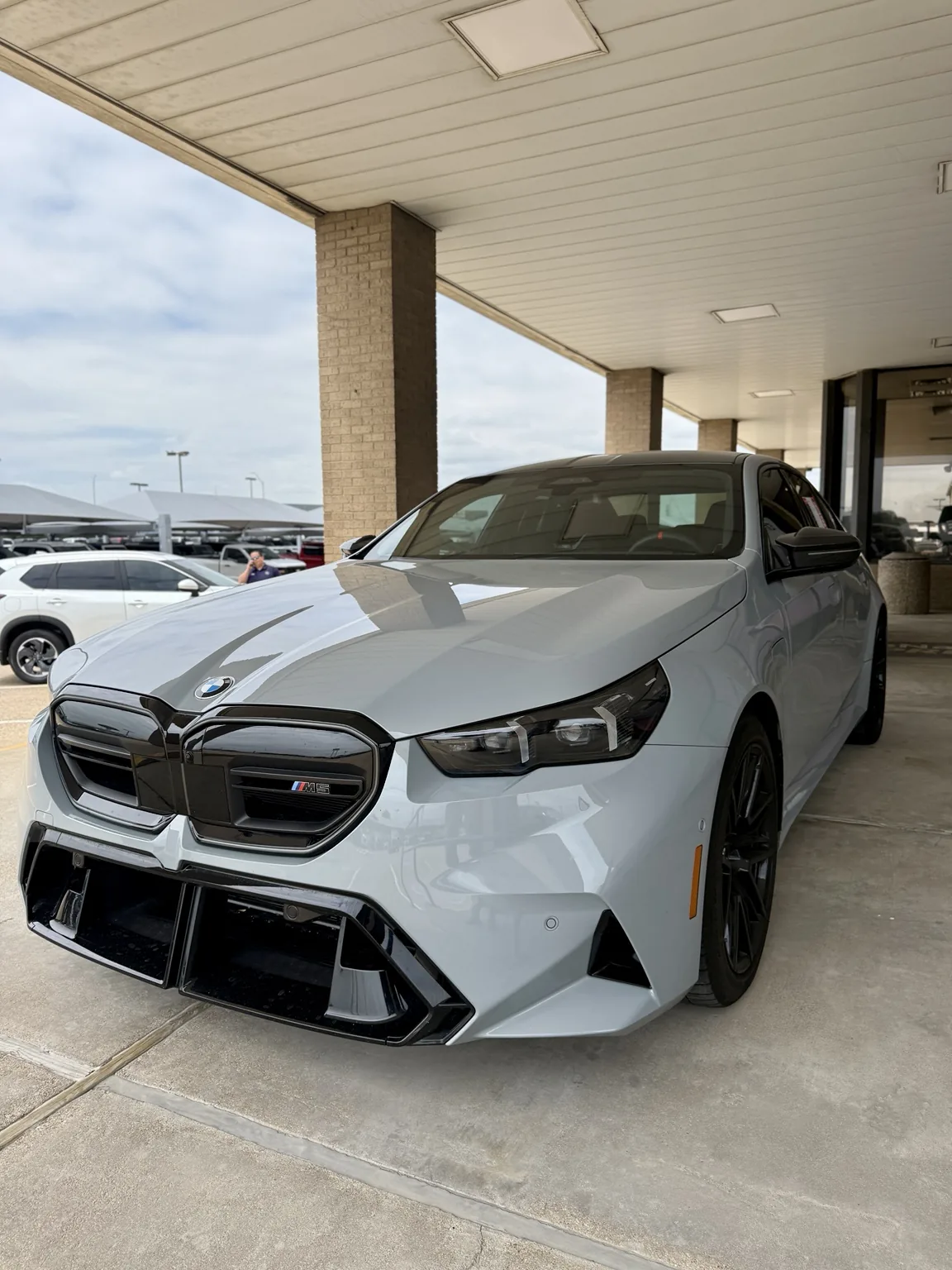 White BMW M5 photographed at a dealership