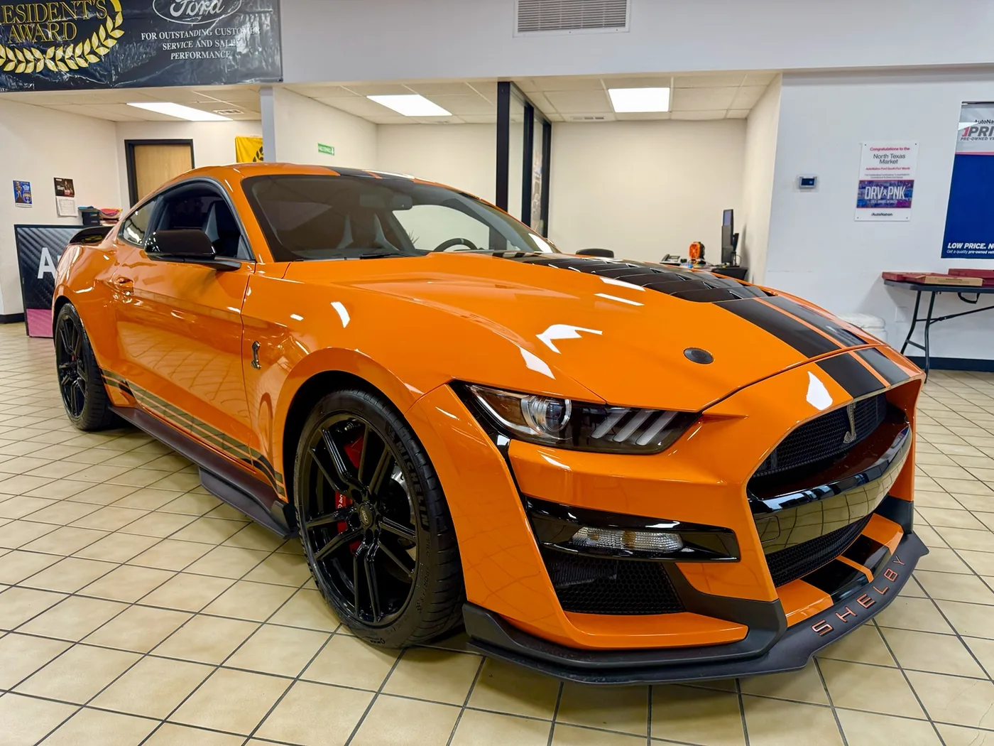 Orange Shelby GT500 photographed inside a dealership
